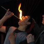 Lehrer leitet den Trick Feuerschlucken an