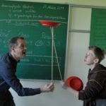 Lehrer übergibt Teller an Schüler