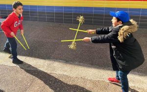 Zwei Kinder werfen sich Flowerstick zu
